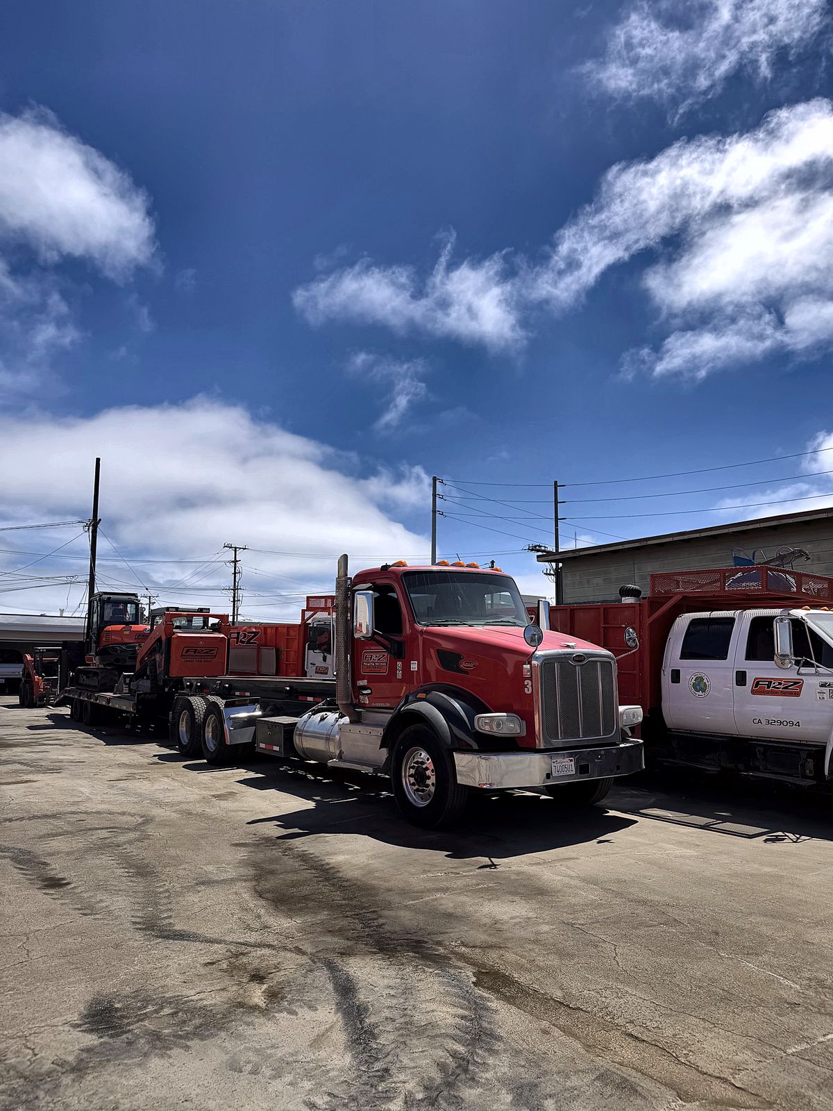 A2Z roll off truck, excavator on a trailer and crew truck ready for a demolition job