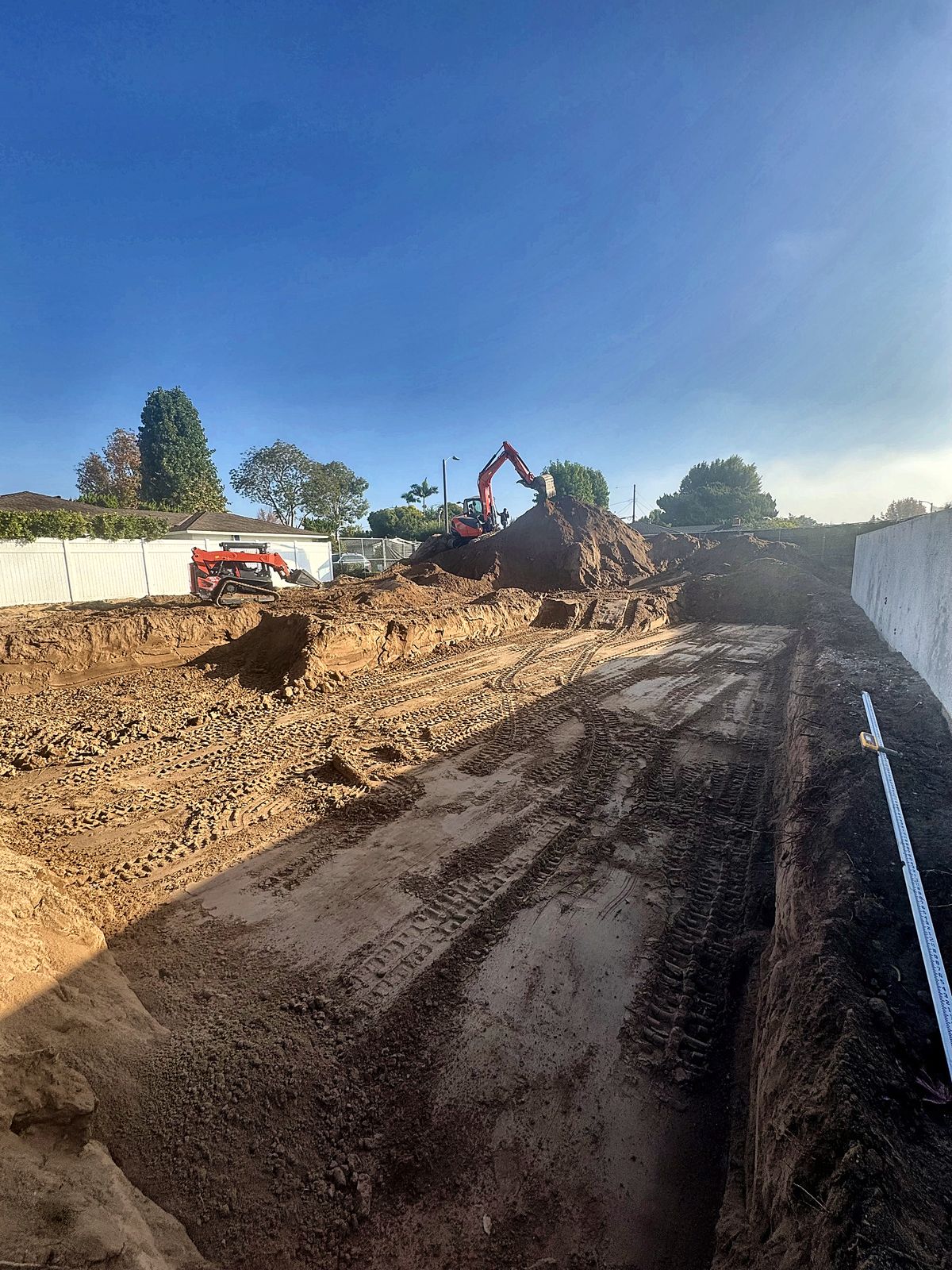 A2Z excavator and skid steer cutting and grading a building pad for a new home