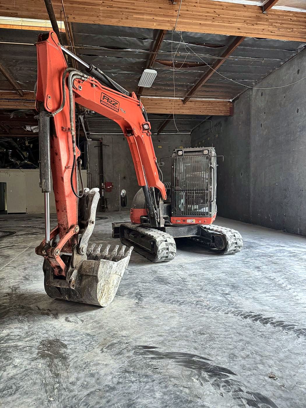 A2Z excavator in a cleared warehouse after interior demolition