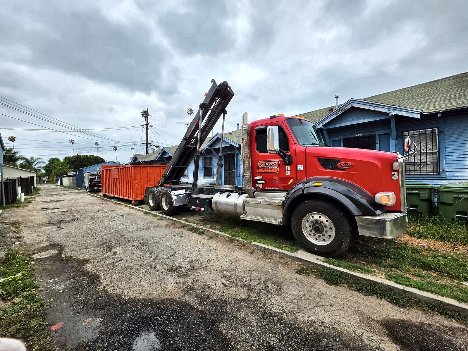 A2Z roll off truck delivering a 40 yard container down an alley
